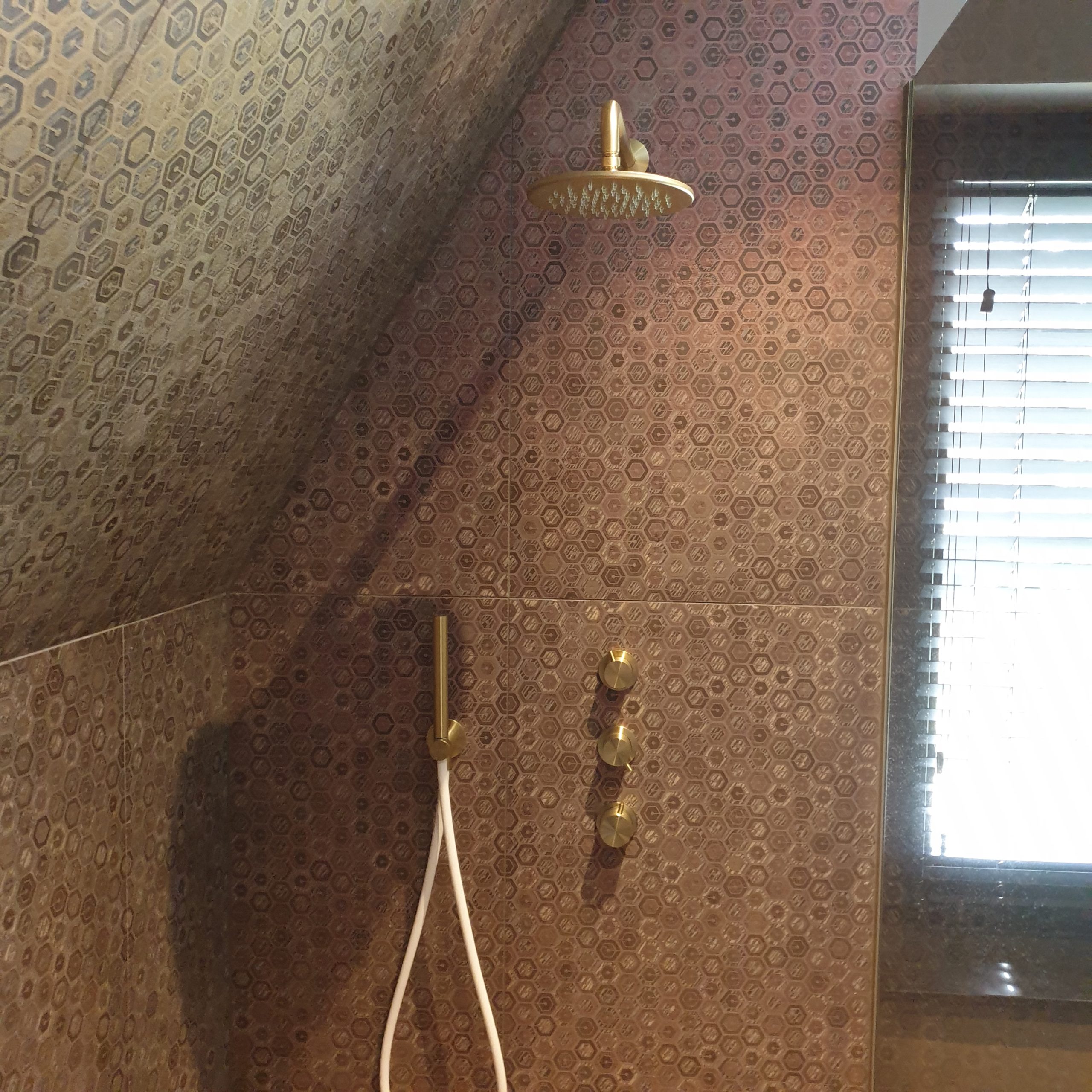 Douche onder schuin plafond met mozaïek